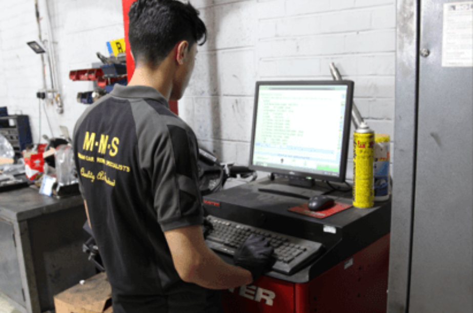 A Martek Motor Services Technician performing diagnostics on a vehicle